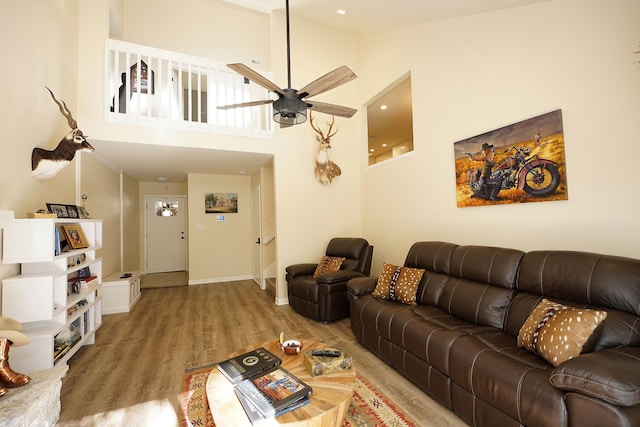 living room featuring ceiling fan, high vaulted ceiling, and wood-type flooring