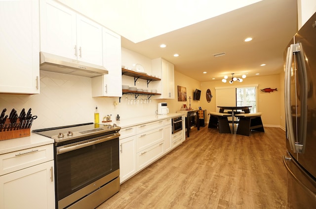 kitchen featuring tasteful backsplash, white cabinetry, stainless steel appliances, and light hardwood / wood-style floors