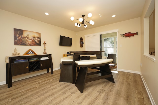 dining area with hardwood / wood-style floors and a notable chandelier