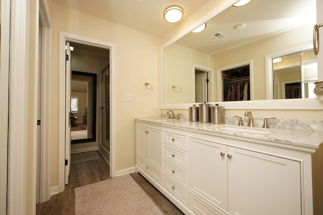 bathroom featuring vanity, hardwood / wood-style flooring, and a shower with shower door