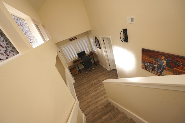 stairway featuring a high ceiling and hardwood / wood-style flooring