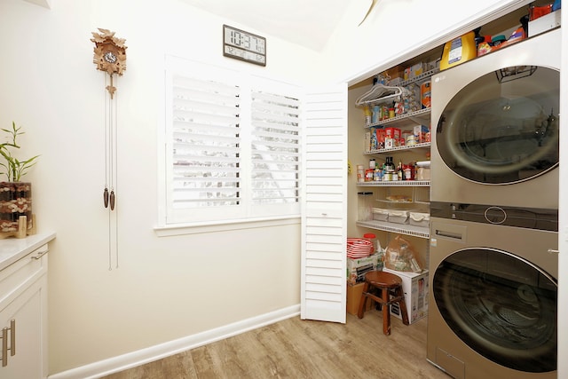 laundry room featuring stacked washer and clothes dryer and light wood-type flooring