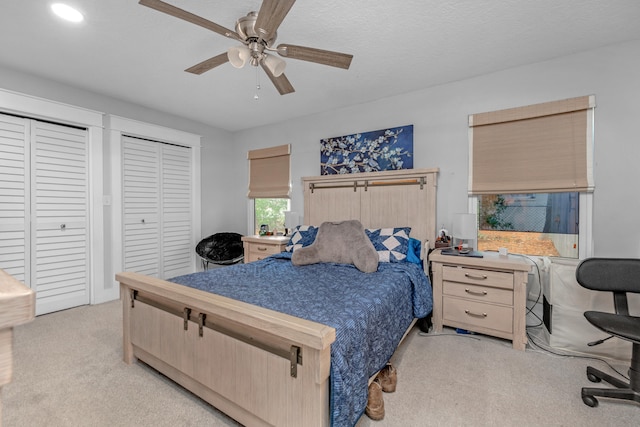 carpeted bedroom with ceiling fan and a textured ceiling