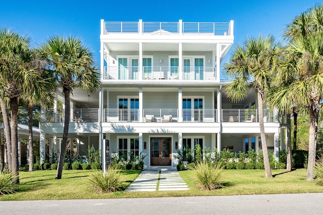 beach home featuring french doors and a front lawn