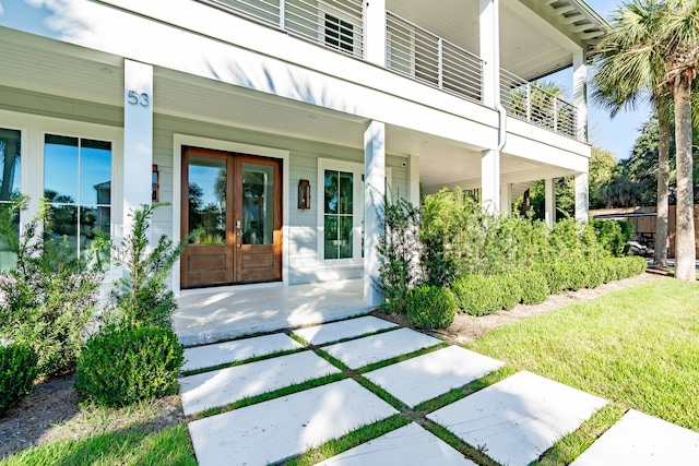 view of exterior entry featuring a porch and french doors