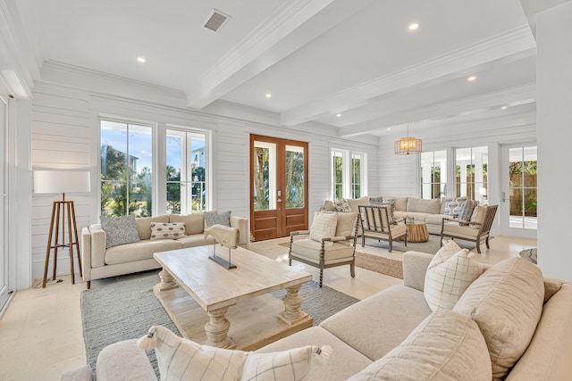 living room with a chandelier, beam ceiling, french doors, and crown molding