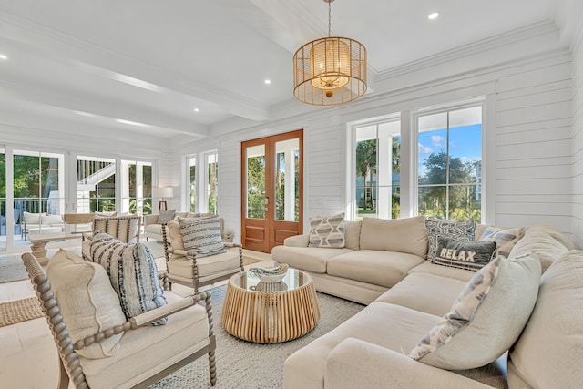 living room with wood walls, beam ceiling, ornamental molding, and french doors