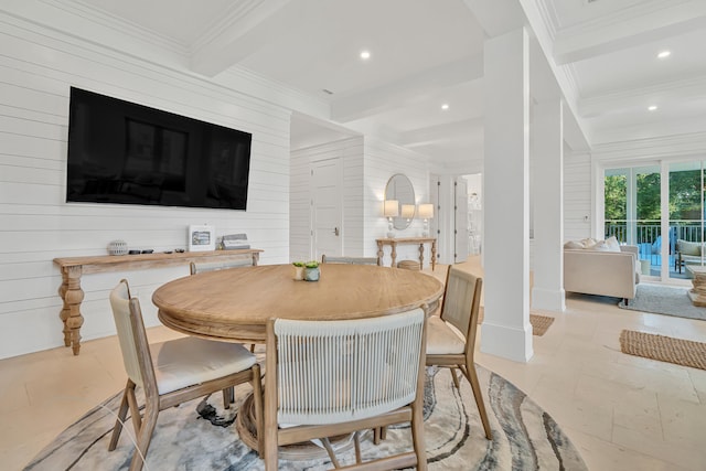 dining room featuring beam ceiling, ornamental molding, and wooden walls