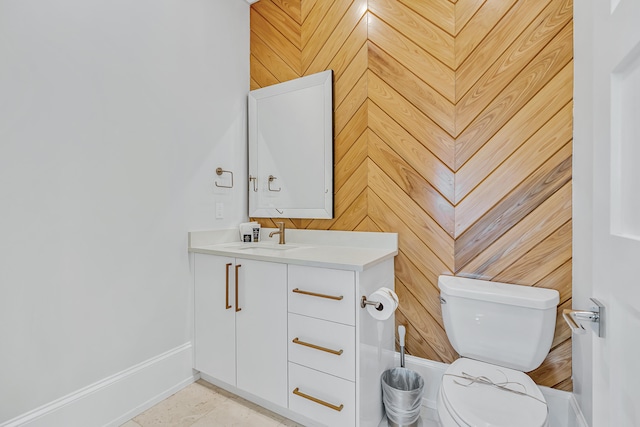 bathroom with wooden walls, vanity, and toilet