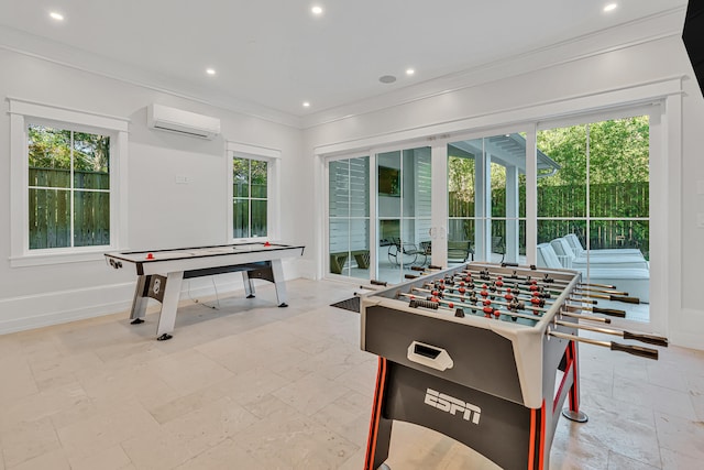 rec room with a wall mounted air conditioner, ornamental molding, and a wealth of natural light