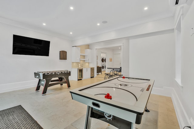 game room featuring beverage cooler and crown molding