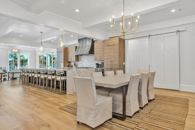 dining space featuring beamed ceiling, a barn door, light hardwood / wood-style flooring, and crown molding