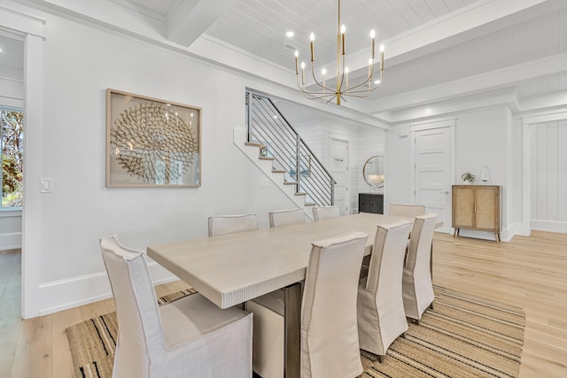 dining space featuring beamed ceiling, light hardwood / wood-style floors, and a chandelier