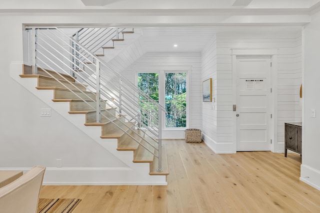 entrance foyer with wood walls and hardwood / wood-style flooring