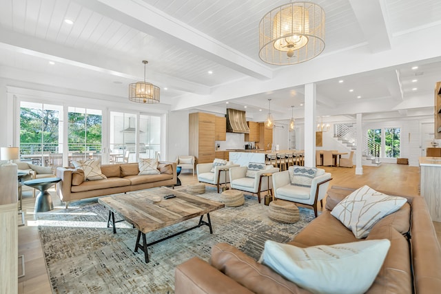 living room featuring beamed ceiling, light wood-type flooring, and a notable chandelier