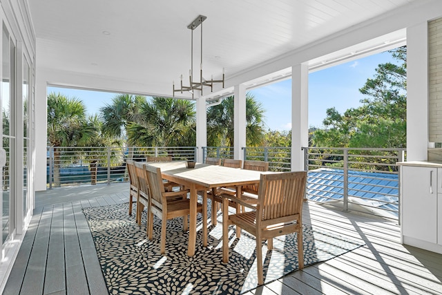 sunroom / solarium featuring a chandelier