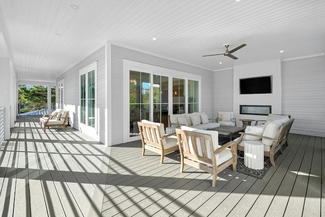 wooden deck with outdoor lounge area and ceiling fan