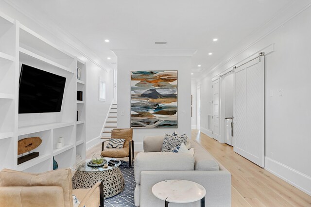 living room with built in features, wood-type flooring, and ornamental molding