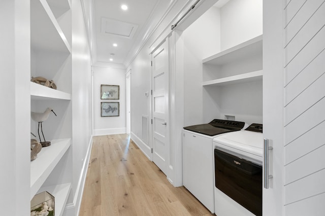 washroom featuring ornamental molding, light wood-type flooring, and independent washer and dryer