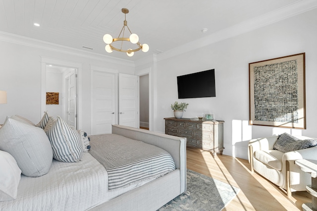 bedroom with light hardwood / wood-style flooring, an inviting chandelier, and crown molding