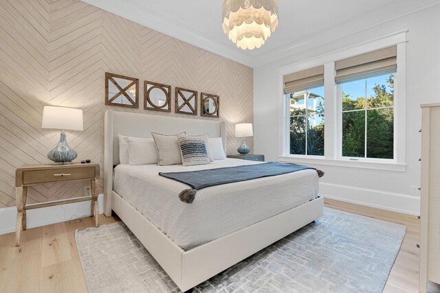 bedroom with wooden walls, hardwood / wood-style floors, and ornamental molding