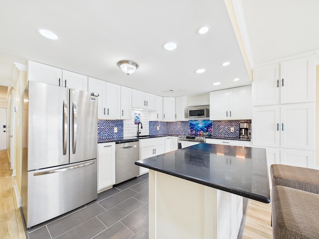 151 Calhoun Ave Unit 301, Destin, FL 32541 - kitchen featuring white cabinets, stainless steel appliances, decorative backsplash, and a sink