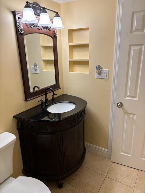 151 Calhoun Ave Unit 301, Destin, FL 32541 - half bathroom with tile patterned flooring, built in shelves, vanity, baseboards, and toilet