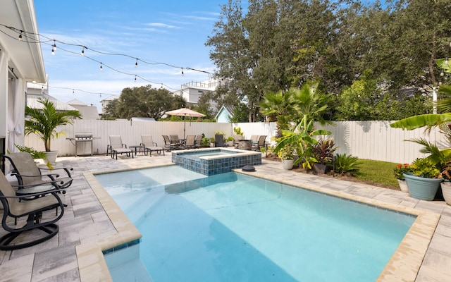 view of pool with a patio area, area for grilling, and an in ground hot tub