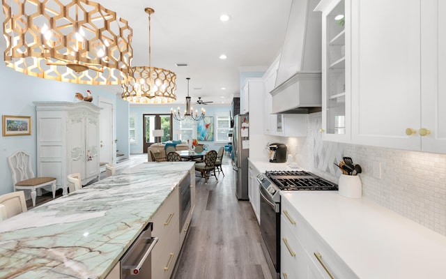 kitchen featuring stainless steel appliances, backsplash, and white cabinets