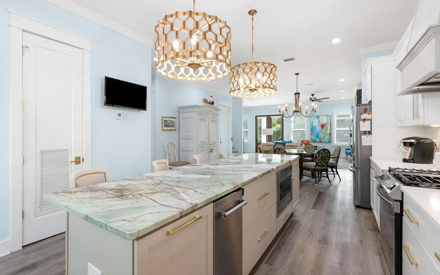 kitchen featuring ceiling fan, decorative light fixtures, white cabinetry, and a center island