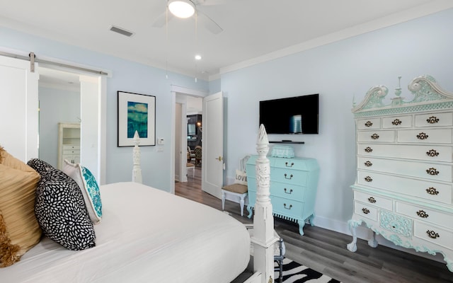 bedroom featuring ceiling fan, hardwood / wood-style floors, crown molding, and a barn door