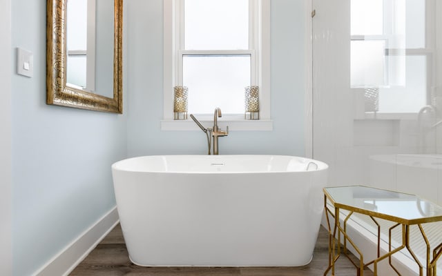 bathroom with wood-type flooring and a bathtub