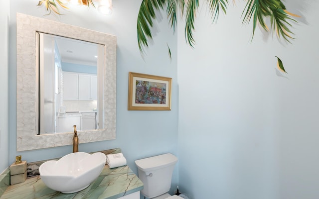 bathroom featuring toilet, tasteful backsplash, and vanity