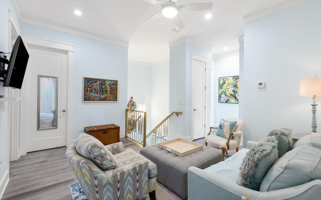 living room with ceiling fan, crown molding, and light wood-type flooring