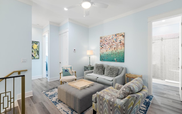 living room with light hardwood / wood-style floors, crown molding, and ceiling fan