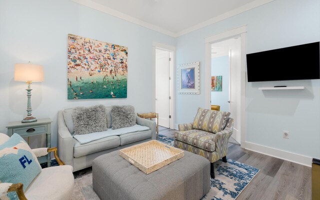 living room with wood-type flooring and ornamental molding