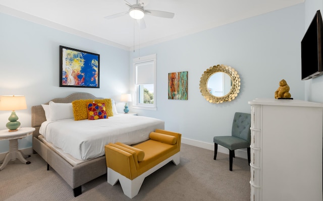 carpeted bedroom featuring ceiling fan and crown molding