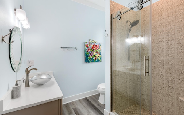 bathroom featuring toilet, walk in shower, hardwood / wood-style flooring, and vanity