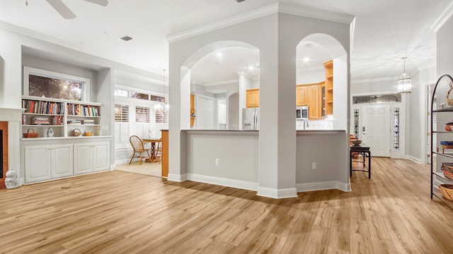 kitchen featuring ceiling fan, ornamental molding, and light hardwood / wood-style flooring