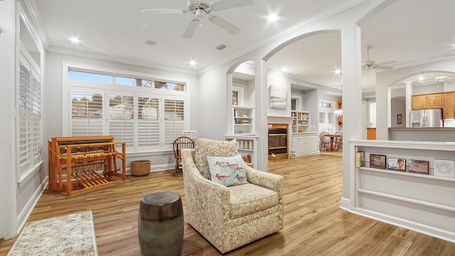 sitting room with light hardwood / wood-style floors, ceiling fan, and ornamental molding