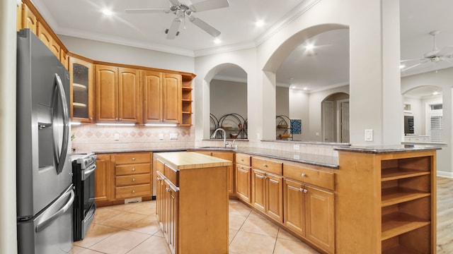 kitchen with kitchen peninsula, stainless steel appliances, crown molding, sink, and a center island