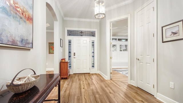 foyer with light hardwood / wood-style floors and crown molding