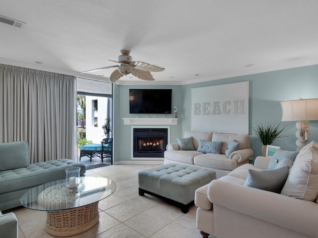 tiled living room with a textured ceiling, ceiling fan, and crown molding