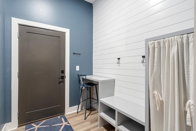 mudroom with wooden walls and light hardwood / wood-style flooring