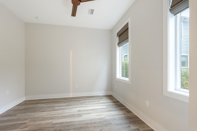 empty room featuring light wood-type flooring, a wealth of natural light, and ceiling fan