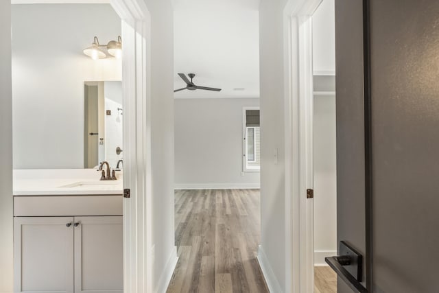 bathroom featuring ceiling fan, hardwood / wood-style floors, vanity, and walk in shower