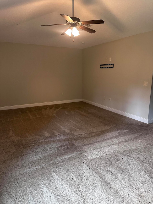 carpeted empty room with vaulted ceiling and ceiling fan