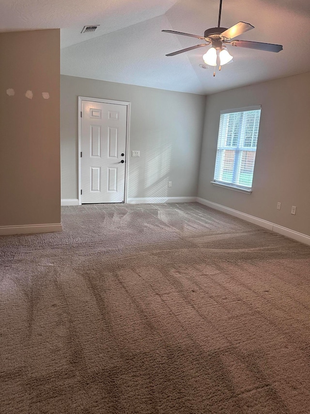 spare room featuring ceiling fan, carpet floors, and lofted ceiling