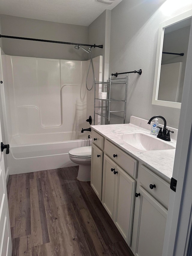 full bathroom featuring hardwood / wood-style floors, vanity, toilet, and shower / tub combination