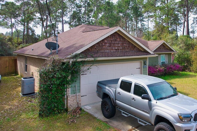 view of front of house with driveway, a shingled roof, fence, and cooling unit